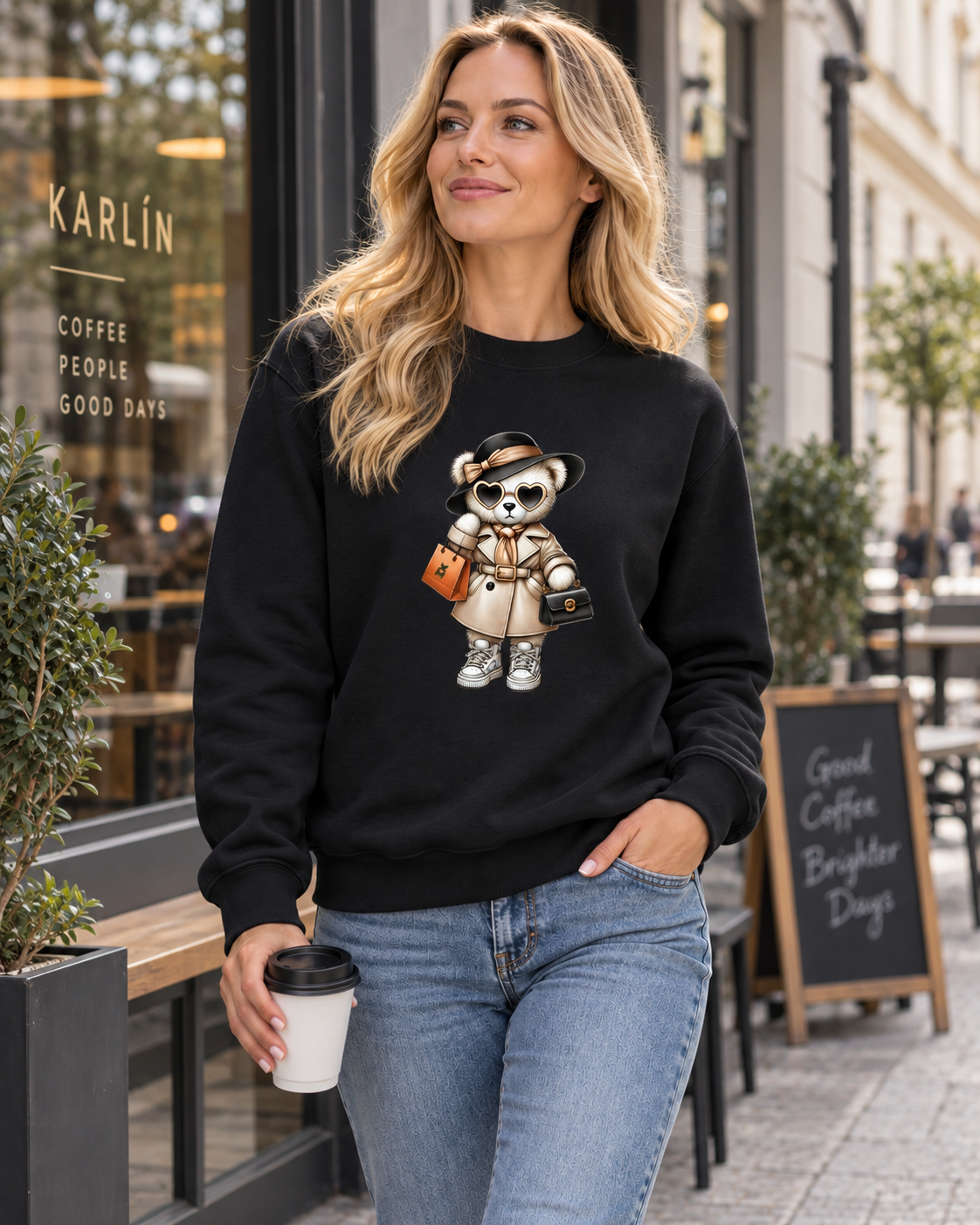 Žena v černé mikině s medvídkem Miss Bear u kavárny v pražském Karlíně.
