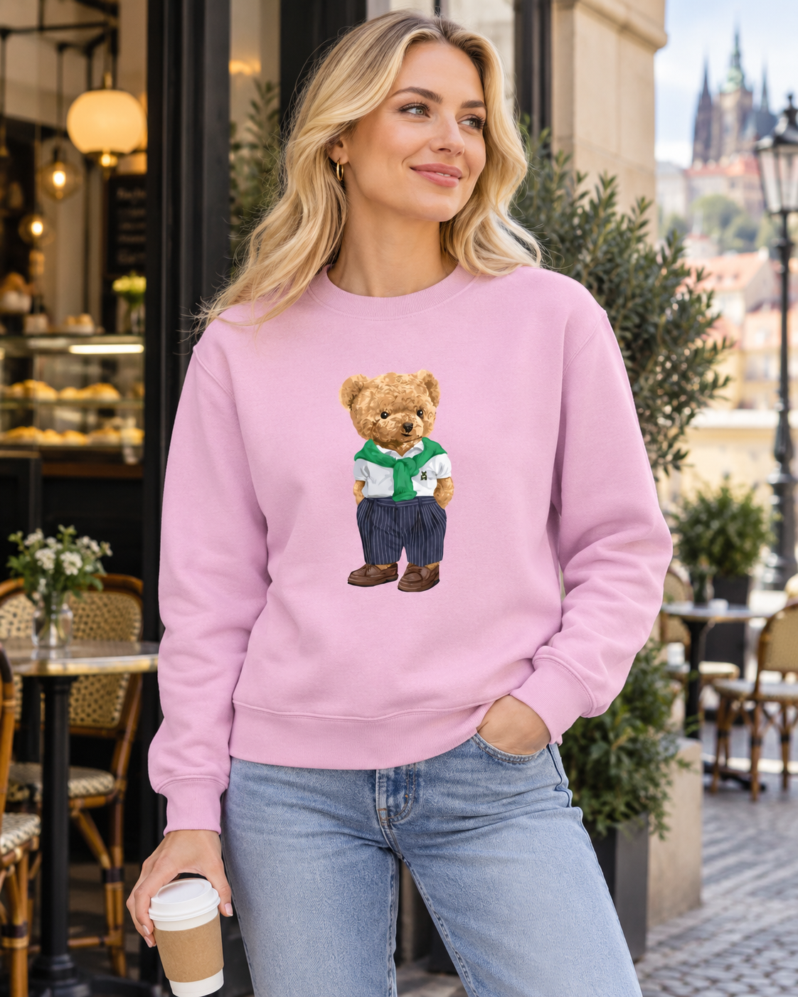 Žena v růžové mikině s medvídkem Street Bear u pražské kavárny.
