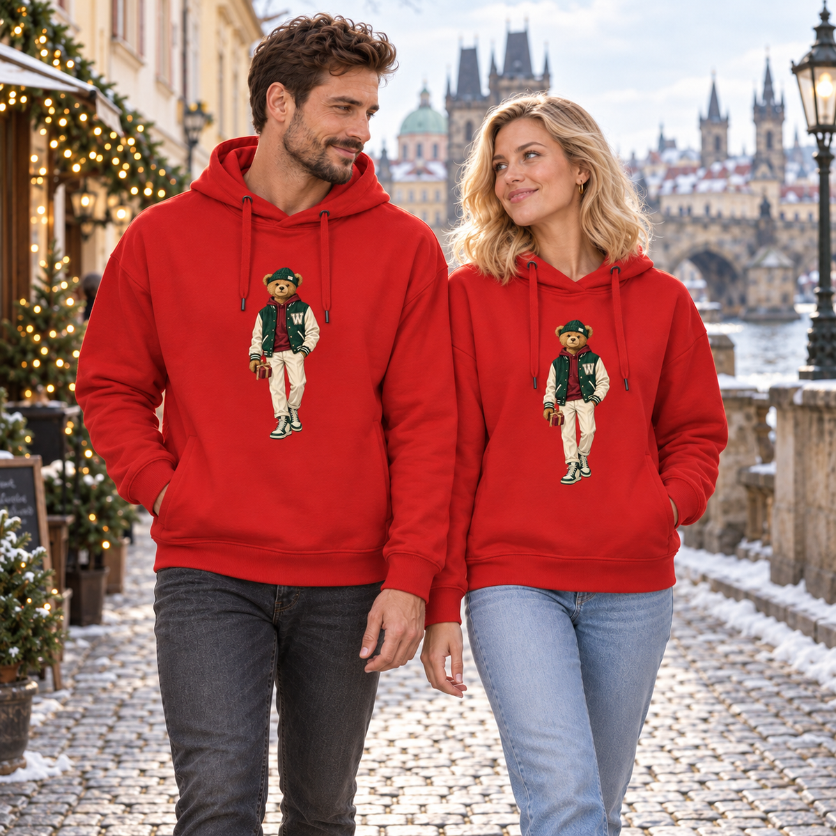 Man and blonde woman in red Winter Club bear hoodies walking together through Christmas Prague.