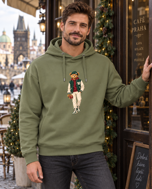 Man in a khaki Winter Club bear hoodie outside a festively decorated café.